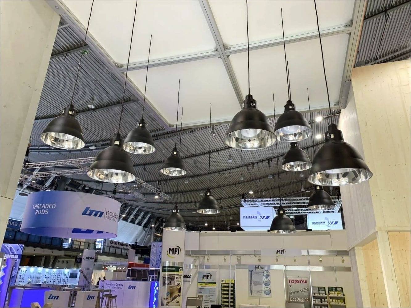 Messestand mit schwarzen lampenschirmen von der decke hängend-expoline